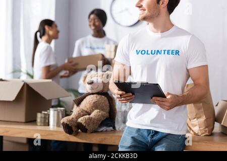 Selektiver Fokus der Freiwilligen hält Zwischenablage und Stift in der Nächstenliebe Zentrieren Stockfoto