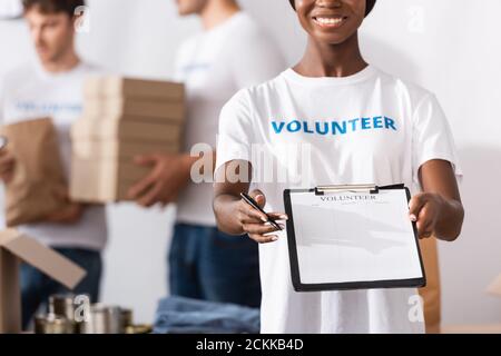 Selektiver Fokus der afroamerikanischen Freiwilligen hält Zwischenablage und Stift Im Charity Center Stockfoto