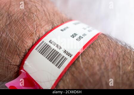 Nahaufnahme eines NHS-Krankenhaus-Handgelenkband-Identifikations-Tags Stockfoto