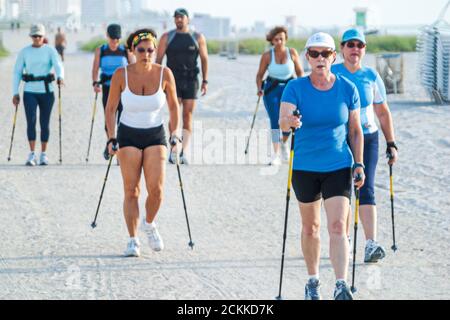 Miami Beach Florida, Training Nordic Walkers Walking Stöcke Ski Fitness, Aktivität auf Sand öffentlichen Stränden, Gruppe Menschen mit Frauen aktiv reifen Stockfoto