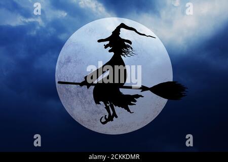 Halloween Hexe. Silhouette von lächelnden böse Hexe fliegen auf Broomstick mit Hut mit einer Warze auf der Nase auf dunklen gruseligen Nacht wolkigen Himmel Hintergrund. Stockfoto