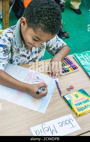 Miami Florida, Frederick Douglass Elementary School, in einem Viertel mit niedrigem Einkommen, in dem Armut herrscht, schwarze afrikanische Minderheit, Student, Junge, Klassenzimmer, Schreibtischzeichnung Stockfoto