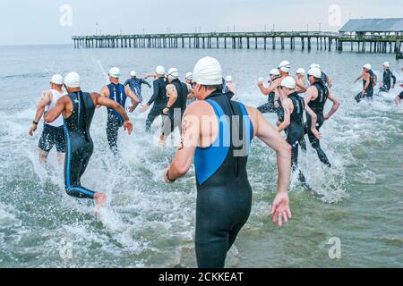 Hampton Virginia,Tidewater Area,Buckroe Beach,Tri American Triathlon jährliche Veranstaltung,Schwimmer Männer männliche Teilnehmer beginnen ein Wettlauf ins Wasser Stockfoto