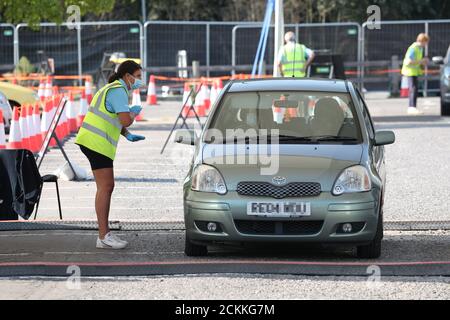 NUMMERNSCHILD UND GESICHTER VERPIXELT VON PA-PERSONAL, das in einem Coronavirus-Testzentrum im Chessington World of Adventures Resort im Südwesten Londons arbeitet. Stockfoto