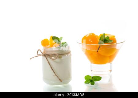 Hausgemachter süßer Joghurt mit Scheiben eingelegter Pfirsiche in einem Glasgefäß Stockfoto