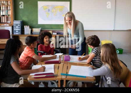 Weibliche Lehrerin mit digitalen Tablet-Unterricht Gruppe von Kindern an Schule Stockfoto