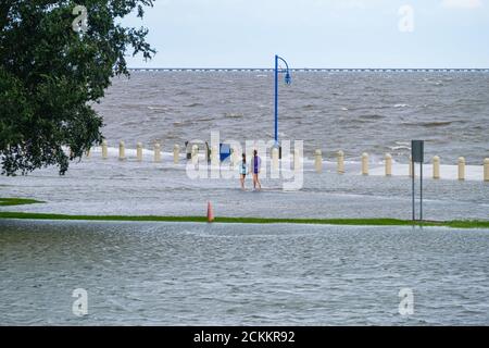 New Orleans, Louisiana/USA - 15. September 2020: Zwei Mädchen waten in überschwemmten Straßen entlang des Lake Pontchartrain Stockfoto