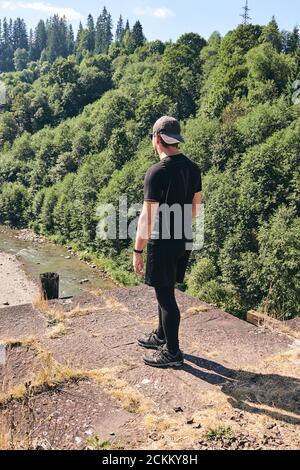 Man klettert auf den Dampffluss des Berges. Sportliche Kleidung und Rucksack. Wanderschuhe in Outdoor-Action. Top Ansicht von Boot auf dem Trail. Nahaufnahme der Beine im Sport Stockfoto