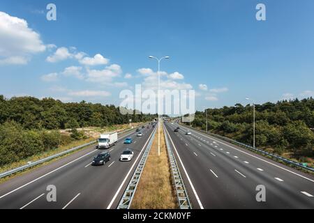 Mehrspurige Autobahn in den Niederlanden gegen einen blauen Himmel Mit wenigen Wolken Stockfoto