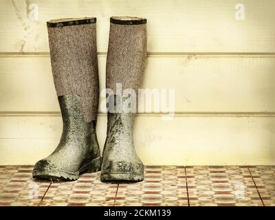 Retro-Stil Bild von einem alten Paar Stiefel gegen Ein Holzhintergrund Stockfoto