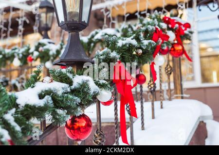 Weihnachten Stadtbild - Dekoration Geländer Veranda am Vorabend des Urlaubs. Weihnachtskugeln und Bänder. Winterurlaub. Stockfoto