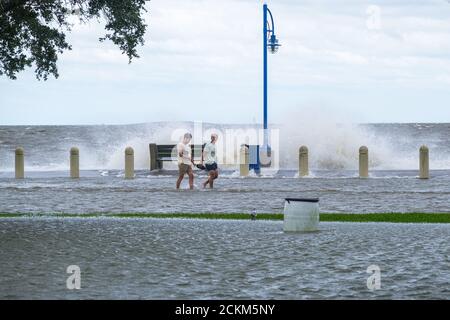 New Orleans, Louisiana/USA - 15. September 2020: Zwei Männer, die während des Sturmflugs des Hurrikans Sally entlang des überfluteten Lakeshore Drive und des Lake Pontchartrain wandern Stockfoto