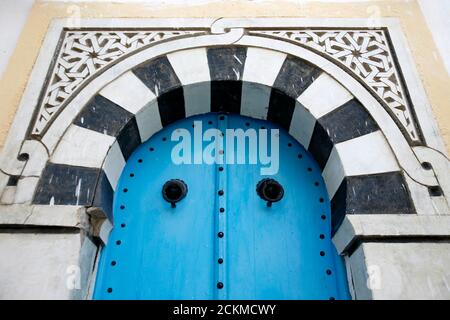 Eine traditionelle Tür in einer Gasse in der Altstadt von Sidi Bou Said in der Nähe der Stadt Tunis im Norden von Tunesien in Nordafrika, Tunesien, Sidi Bou Sair, Ma Stockfoto