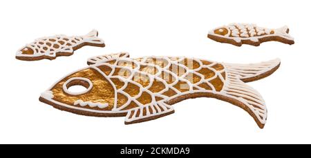 Süße goldene Fische aus weihnachtlichen Lebkuchen isoliert auf weißem Hintergrund. Niedliche Goldkeks für Viel Glück. Gebackene kleine und große Fisch geformte Tiere. Stockfoto