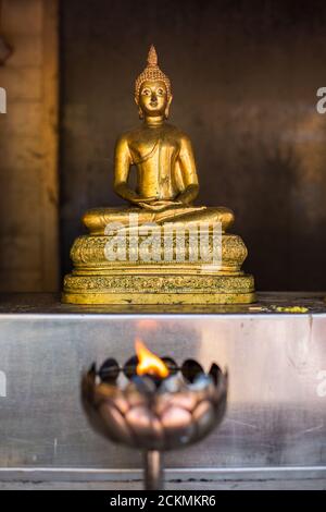 Kerzen an einem Tempel mit einem goldenen buddha im Hintergrund, thailand Stockfoto