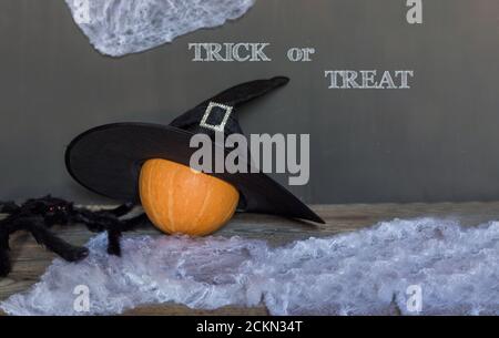 Tricksen oder behandeln Sie Grußtext auf dunklem Holz- und Blackboard-Hintergrund. Stockfoto