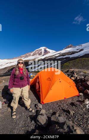 Karen Rentz und Zelt im Hogsback Camp, einem Klettercamp auf Heliotrope Ridge an den Hängen des Mount Baker, Mount Baker-Snoqualmie National Forest, Wash Stockfoto