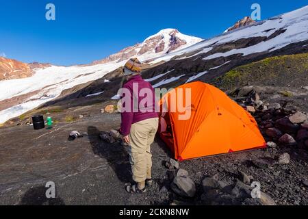 Karen Rentz und Zelt im Hogsback Camp, einem Klettercamp auf Heliotrope Ridge an den Hängen des Mount Baker, Mount Baker-Snoqualmie National Forest, Wash Stockfoto