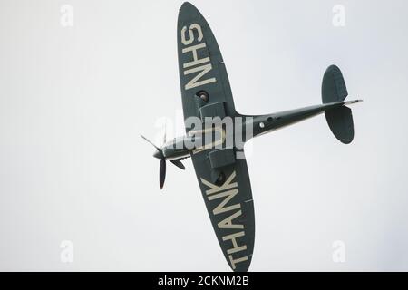 Cumbernauld, Schottland, Großbritannien. September 2020. Im Bild: Sonderflug eines spitfire-Flugzeugs mit der auf die Rumpfunterseite gemalten Botschaft „THANK U NHS“ wird vor einer Menschenmenge, die sich vor dem Flughafen Cumbernauld versammelt hat, beim Kunstflug gesehen, bevor es für den Abend landet. Morgen geht die spitfire auf Schottland-Rundreise über verschiedene Krankenhäuser und dankt dem NHS für seine harte Arbeit während der Coronavirus-Pandemie (COVID-19). Quelle: Colin Fisher/Alamy Live News Stockfoto