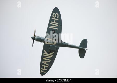 Cumbernauld, Schottland, Großbritannien. September 2020. Im Bild: Sonderflug eines spitfire-Flugzeugs mit der auf die Rumpfunterseite gemalten Botschaft „THANK U NHS“ wird vor einer Menschenmenge, die sich vor dem Flughafen Cumbernauld versammelt hat, beim Kunstflug gesehen, bevor es für den Abend landet. Morgen geht die spitfire auf Schottland-Rundreise über verschiedene Krankenhäuser und dankt dem NHS für seine harte Arbeit während der Coronavirus-Pandemie (COVID-19). Quelle: Colin Fisher/Alamy Live News Stockfoto