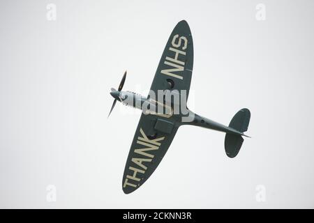 Cumbernauld, Schottland, Großbritannien. September 2020. Im Bild: Sonderflug eines spitfire-Flugzeugs mit der auf die Rumpfunterseite gemalten Botschaft „THANK U NHS“ wird vor einer Menschenmenge, die sich vor dem Flughafen Cumbernauld versammelt hat, beim Kunstflug gesehen, bevor es für den Abend landet. Morgen geht die spitfire auf Schottland-Rundreise über verschiedene Krankenhäuser und dankt dem NHS für seine harte Arbeit während der Coronavirus-Pandemie (COVID-19). Quelle: Colin Fisher/Alamy Live News Stockfoto