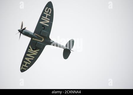 Cumbernauld, Schottland, Großbritannien. September 2020. Im Bild: Sonderflug eines spitfire-Flugzeugs mit der auf die Rumpfunterseite gemalten Botschaft „THANK U NHS“ wird vor einer Menschenmenge, die sich vor dem Flughafen Cumbernauld versammelt hat, beim Kunstflug gesehen, bevor es für den Abend landet. Morgen geht die spitfire auf Schottland-Rundreise über verschiedene Krankenhäuser und dankt dem NHS für seine harte Arbeit während der Coronavirus-Pandemie (COVID-19). Quelle: Colin Fisher/Alamy Live News Stockfoto