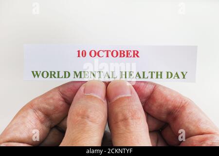 Person, die ein Stück Papier mit den Worten Welttag der psychischen Gesundheit hält (10. Oktober). Nahaufnahme. Stockfoto