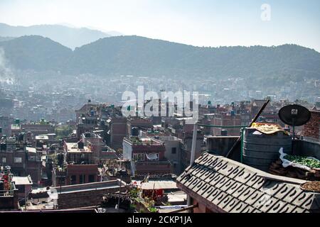 Bhaktapur, Kathmandu, Nepal - 23. Dezember 2019: Blick auf die Stadt von einem Dach über Obst und Gemüse, das in der Sonne trocknet und die Stadt im Hintergrund Stockfoto