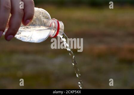 Reines frisches klares Wasser wird aus einer Plastikflasche gegossen. Stockfoto