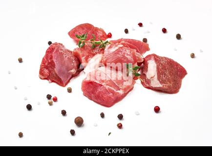 Geschnittenes Hammelfleisch mit Thymian-Kraut und Paprika auf weiß isoliert mischen. Stücke von rohem Hammelfleisch. Stockfoto