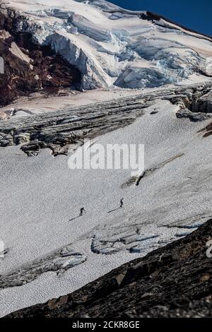 Bergsteiger, die den Coleman Glacier nach ihrer erfolgreichen Besteigung des Mount Baker, Mount Baker-Snoqualmie National Forest, Washington State, USA, besteigen [Keine Mod Stockfoto