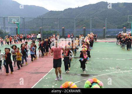 (200915) -- LINGYUN, 15. September 2020 (Xinhua) -- Shen Yequan (C, Front) und Studenten laufen während einer Klassenpause in der Lanjin Grundschule in Sicheng, Bezirk Lingyun, südchinesische Provinz Guangxi Zhuang, am 10. September 2020 auf dem Basketballplatz. Shen, 28, ist der einzige PE-Lehrer der Dorfschule. Er wurde beauftragt, zu lehren körperliche Bildung in der Schule in 2018 nach dem Abschluss mit einem Bachelor-Abschluss in Sport. "Aufgrund unserer unerbittlichen Bemühungen haben Kinder einen starken Wunsch nach körperlichen Aktivitäten. Ich werde hier an meinem Posten bleiben, um ländlichen Kindern zu helfen, die Gewohnheit zu kultivieren Stockfoto