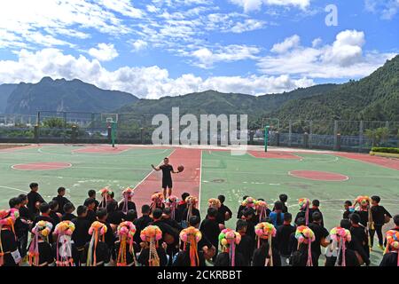 (200915) -- LINGYUN, 15. September 2020 (Xinhua) -- Shen Yequan (Top) gibt einen Basketballkurs für Schüler der Lanjin Grundschule in Sicheng Gemeinde Lingyun Bezirk, Südchina Guangxi Zhuang Autonome Region, 8. September 2020. Shen, 28 Jahre alt, ist der einzige PE-Lehrer der Dorfschule. Er wurde beauftragt, zu lehren körperliche Bildung in der Schule in 2018 nach dem Abschluss mit einem Bachelor-Abschluss in Sport. "Aufgrund unserer unerbittlichen Bemühungen haben Kinder einen starken Wunsch nach körperlichen Aktivitäten. Ich werde hier bei meinem Posten bleiben, um ländlichen Kindern zu helfen, die Gewohnheit zu pflegen, Sport zu treiben Stockfoto