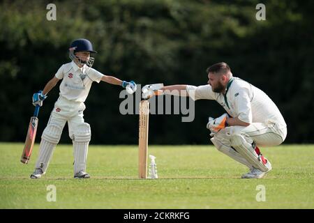 Junger Batsman und Erwachsener Wicket Keeper Faustschlag während Dorf Cricket Tatsache für alle Altersgruppen. Stockfoto