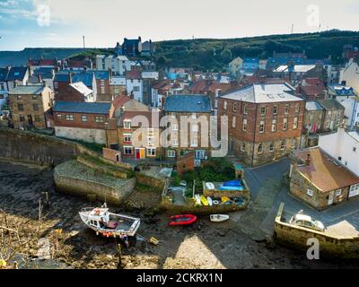 Traditionelle Häuser im historischen Fischerdorf Staithes North Yorkshire England mit Booten auf Roxby Beck Stockfoto