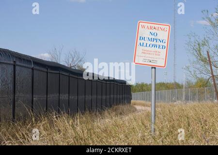 Laredo, TX USA, 20. Februar 2009: Ein Metallzaun hinter dem Laredo Community College schützt die Nachbarschaft vor dem Eindringen illegaler Ausländer, die den nahe gelegenen Rio Grande River in die USA überqueren ©Bob Daemmrich Stockfoto