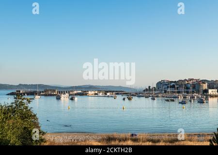 Weitwinkelansicht des Strandes und des Sporthafens von Portonovo in der Ria de Pontevedra in der Abenddämmerung, Spanien. Stockfoto