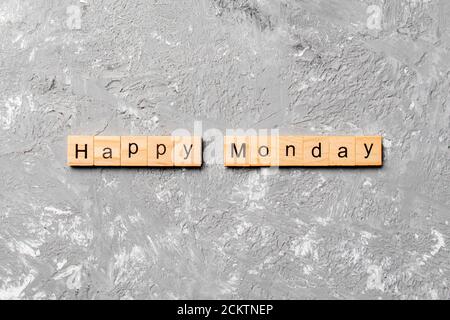 Happy monday Wort auf Holzblock geschrieben. Happy monday Text auf Zementtisch für Ihr Design, Konzept. Stockfoto