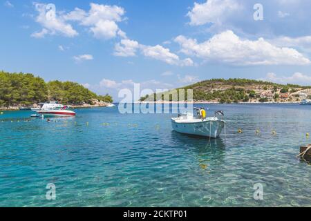 Hvar/ Kroatien-6. August 2020: Wunderschöne, einsame Bucht mit wunderschönem, türkisfarbenem Meer und verankerten Booten um Inseln, die mit grünem Pinienwald bedeckt sind Stockfoto