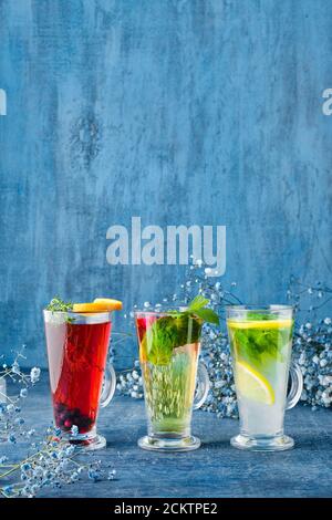 Drei Gläser mit heißem Obst und Kräutertee auf Blau Hintergrund Stockfoto