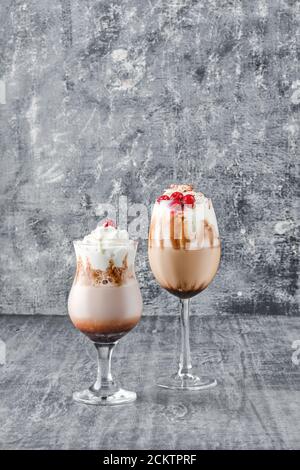 Zwei Gläser mit Latte Drink mit Schlagsahne und Kirsche Stockfoto