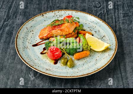 Gebackener Lachs mit gerösteter Karotte, Brokkoli, grünen Bohnen und Tomatenkirsche Stockfoto
