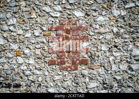 Nahaufnahme eines Mauerwerks aus Ziegel und Feuerstein. Traditionelle Bauweisen. Stockfoto