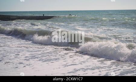 Wellen am schwarzen Sandstrand Rejnisfjara, Zeitlupe. Rasende Wellen auf dem schwarzen Meer in Zeitlupe. Stockfoto