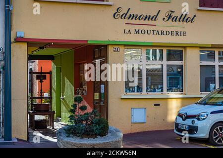Die Beschriftung „Edmond Fallot – La Moutarderie“ steht über dem Eingang an der Hausnummer 31 in der Rue du Faubourg Bretonnière in Beaune in Burgund, Frankreich, eine alte Ölmühlepresse steht im offenen Torbogen. Moutarderie Edmond Fallot produziert seit 1840 an diesem Ort und ist heute der einzige noch verbliebene familiengeführte Senfhersteller Frankreichs und der viertgrößte Senfproduzent des Landes. Stockfoto