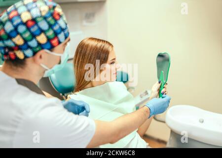 Zahnarzt zeigt Ergebnis der Behandlung für den Patienten Stockfoto
