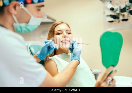 Zahnarzt zeigt Ergebnis der Behandlung für den Patienten Stockfoto