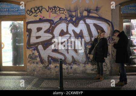 Straßenporträts in Prag, Tschechische Republik - Blick auf ein männliches und weibliches Paar neben einer mit Graffiti bedeckten Tunnelwand Stockfoto