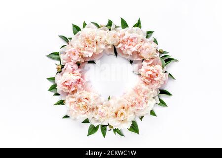 Blumenkranz mit rundem Rahmen aus rosa und beigen Pfingstrosen Blütenknospen, Eukalyptuszweigen und Blättern isoliert auf weißem Hintergrund. Flach liegend, Draufsicht. Stockfoto