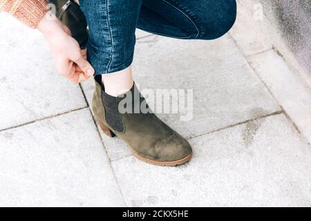 Weibliche Füße, Ansicht von oben und von der Seite. Selfie für jeden Einsatz. Füße und Beine in grünen Schuhen. Fuß steht auf der grauen Fliese. Mit Kopierbereich. Beine außen Stockfoto